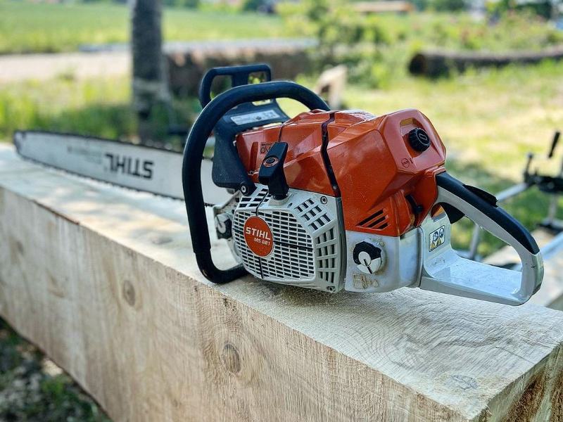 a chainsaw sits on top of a piece of wood.